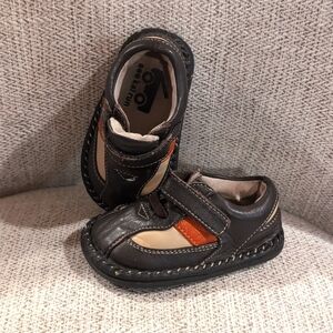 Leather toddler shoes with burnt orange accent stripe. Has some mild wear.